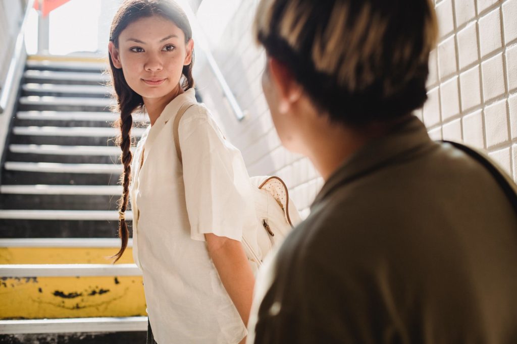 calm ethnic female standing on stairs in city