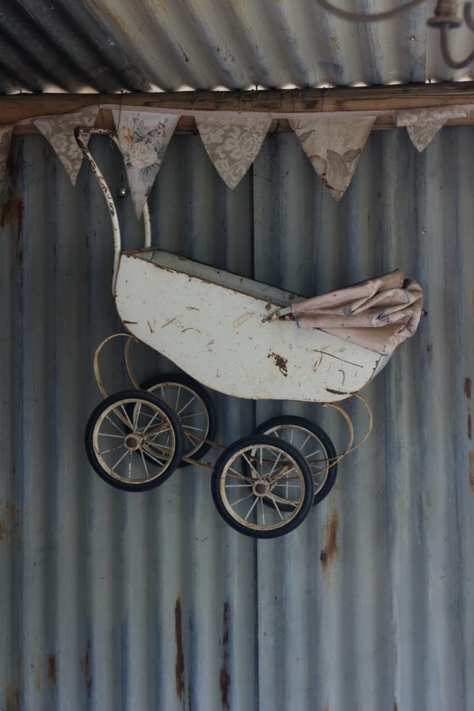 white steel baby carriage hanging from the ceiling